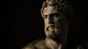 Busto de mármore grego antigo emergindo da penumbra, símbolo de legado e permanência